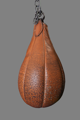 Boxing speed bag, pear shaped, old yellow leather, weathered and worn , isolated
