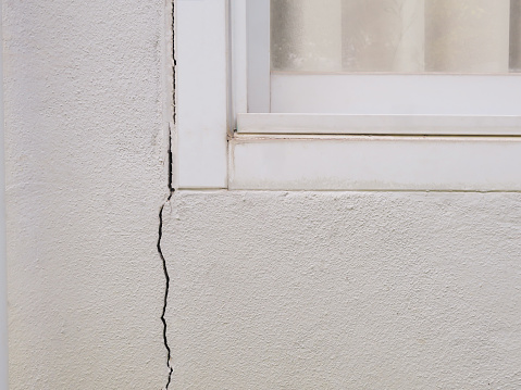 Cracked concrete wall at the adge of building window after earthquake