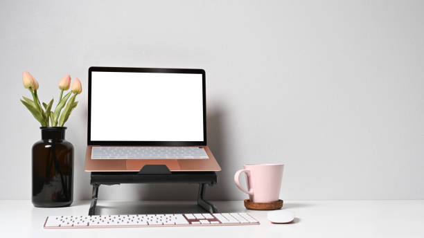 istock Mockup computer laptop, flower pot and coffee cup on white table. 1398063744