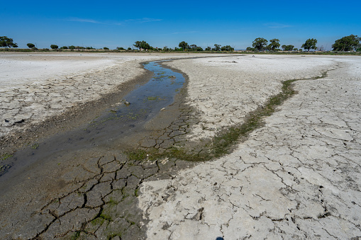 dry and cracked floor of dry river of caldera grande in the city of Barreiro with a small stream.