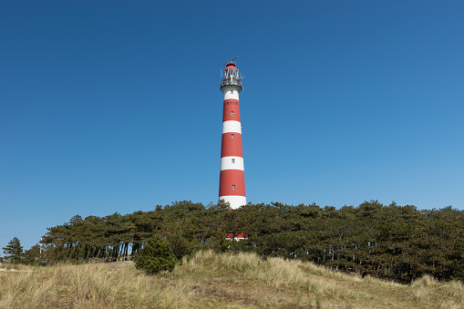 The beautiful classic light house at Ameland island in the Netherlands at a very sunny day.