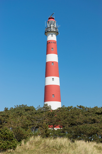 The beautiful classic light house at Ameland island in the Netherlands at a very sunny day.