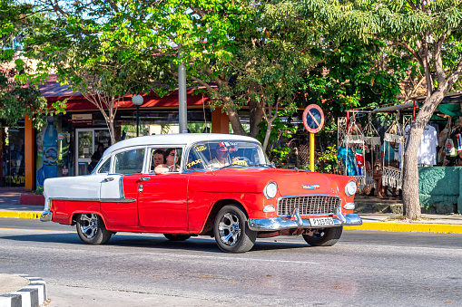 Varadero, Cuba - March 17, 2019: People are seen inside an old Chevrolet that works as a taxi in the resort city. These vintage vehicles are a tourist attraction.