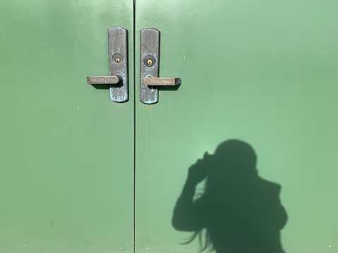 Shadow of a woman taking photo of a door.