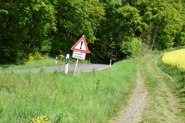 istock dirt road and road with road damage sign 1398067657
