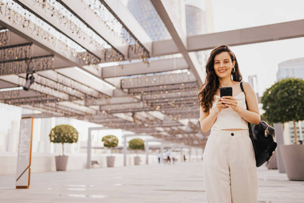 istock Woman using her smart phone on the street 1398069580
