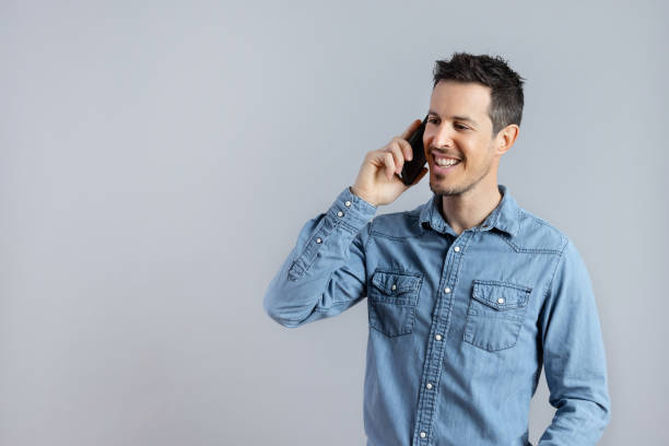 istock Relaxed Man talking on phone in studio shot, copy-space. 1398070346