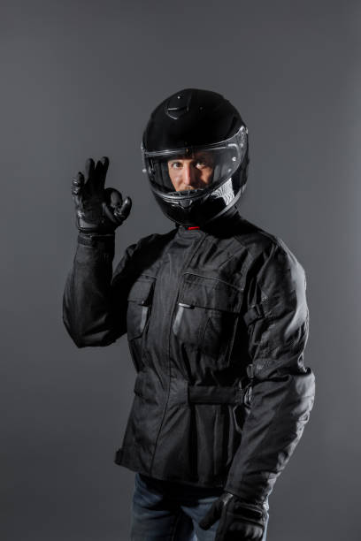 istock Man wearing protective motor black clothing doing ok sign in studio. 1398070660
