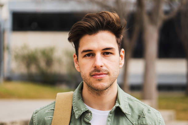 retrato de adolescentes estudantes olhando sério para a câmera em uma faculdade. um cara caucasiano no campus da universidade. - male education college student nerd - fotografias e filmes do acervo