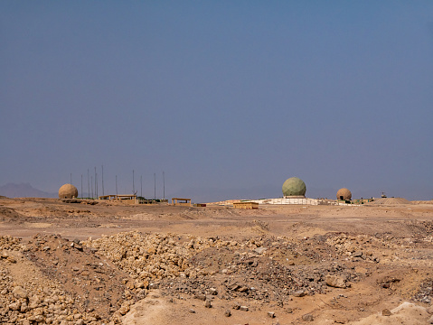 View of a radar station on a desert landscape against a cloudy sky. Weather forecast.