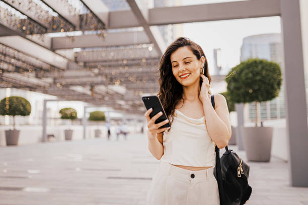 istock Woman using her smart phone on the street 1398072634