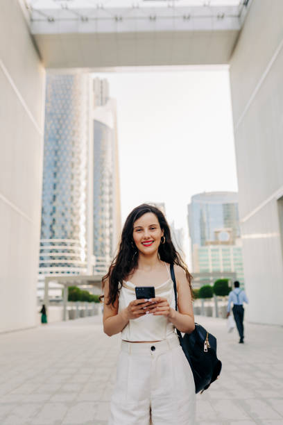 istock Woman using her smart phone on the street 1398073722