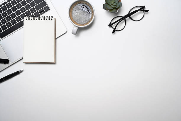 istock Simple workplace with laptop computer, coffee cup, glasses and notebook. Top view, flat lay, copy space. 1398075342