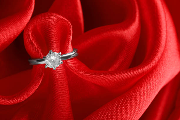 istock Beautiful luxury engagement ring with gemstone on red fabric, closeup 1398075361