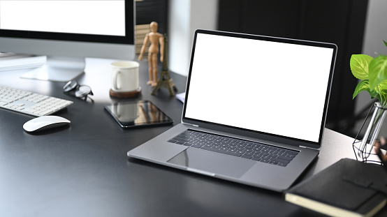 Computer laptop, notebook, smart phone and coffee cup on white office desk. Modern workplace.