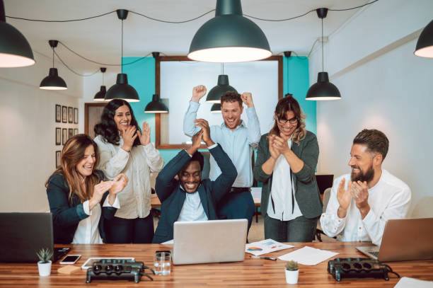 istock Multiracial coworkers celebrating victory at table 1398076826