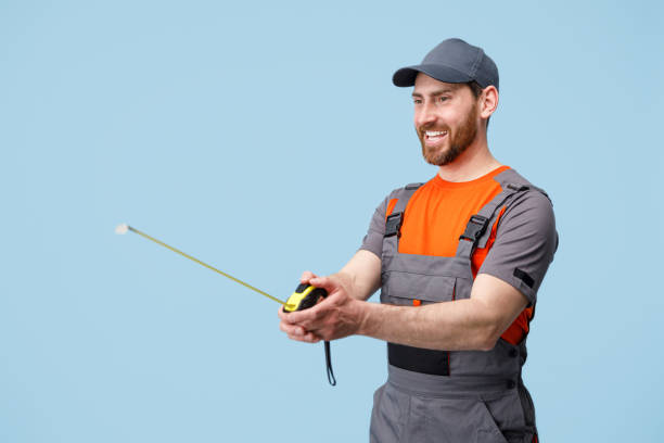 istock Smiling builder worker holding and looks on measuring tape tool. Studio shoot 1398076835