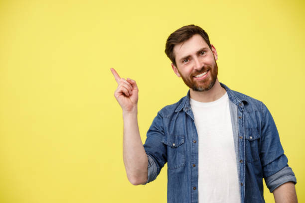 istock Smiling man with beard raising his finger up and pointing to empty space 1398077069