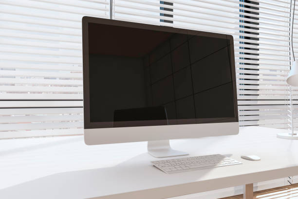 istock Close up of modern creative designer office interior with empty computer screen, headphones and other items on desktop. White blinds and daylight background. Mock up, 3D Rendering. 1398077375