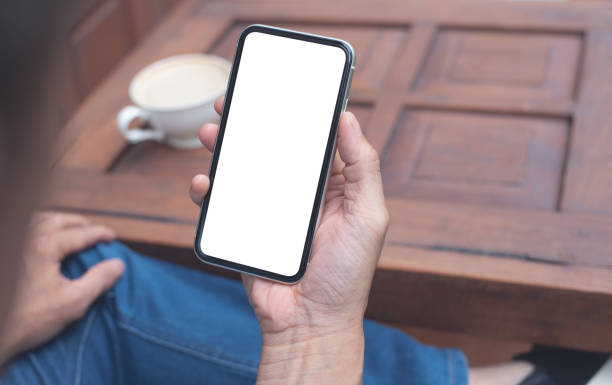 Mockup image blank white screen cell phone. Mockup image blank white screen cell phone. Man hand holding, using mobile relax on sofa at home. background empty space for advertise text. man looking at phone over shoulder stock pictures, royalty-free photos & images