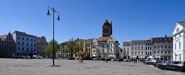 Wismar, Germany, May 8, 2022 - Market square of the historic city center of Wismar, some unidentified people in the background.