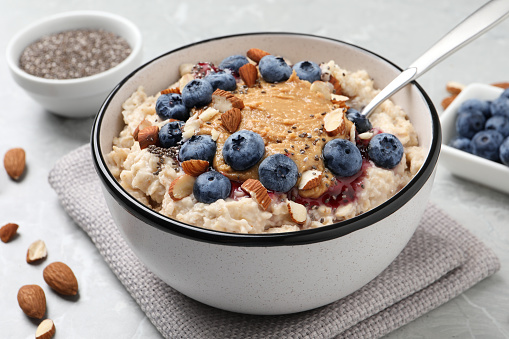 Top view of two lunch boxes with healthy food. Berries, crackers and pistachios in meal boxes over blue background.