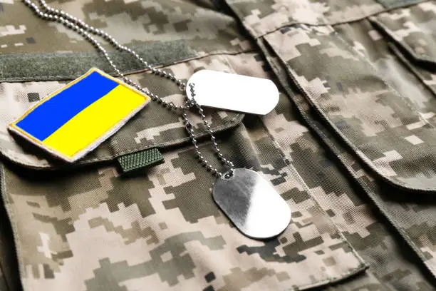 Ukrainian army flag patch and military ID tags on camouflage uniform