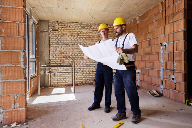 istock Full length of construction workers analyzing blueprints in the apartment. 1398081709