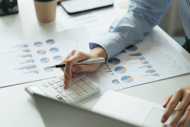 istock Accountant working on desk using calculator for calculate finance report in office. 1398081902