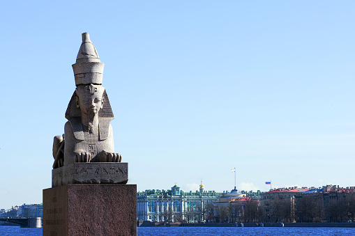 Ancient Egyptian sphinx on display at the embankment in St Petersburg, with view of Neva river, Admirality and  Hermitage
