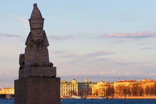 Egyptian sphinx on display at the embankment in St Petersburg, with view of Neva river, Admirality and  Hermitage, sunset