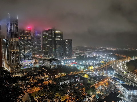 An atmospheric night shot of Singapore's central business district (CBD), during a stormy night with low cloud.