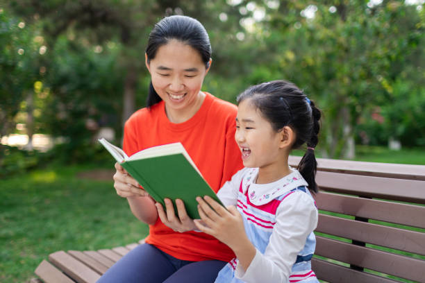 istock Little Girl and Mother Reading Book 1398084510