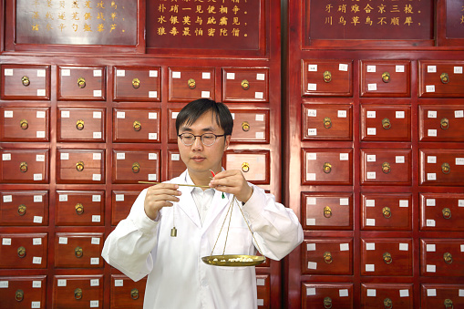 Doctor of Tradional Chinese Medicine dispensing medicine in a Pharmacy