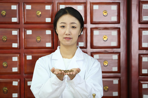 Doctor of Tradional Chinese Medicine dispensing medcine in a Pharmacy