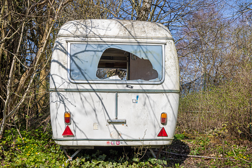 Abandoned caravan with a broken window found in Humlebæk which is a suburb to Copenhagen
