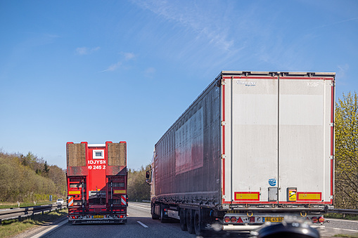 Two trucks overtaking each other on a narrow highway in the center of Jutland