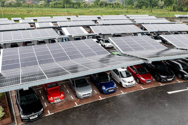 Aerial view of solar panels on a parking lot rooftop Stourton, Leeds, UK - May 16, 2022. Aerial view above innovative solar panels located on a car parking lot rooftops making good use of small space in a city to charge electric vehicles solar panels on the roof of building in a city stock pictures, royalty-free photos & images
