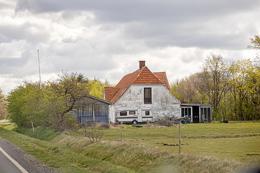 Typical Danish farmhouse with a caravan in front in the central part of the peninsular Jutland