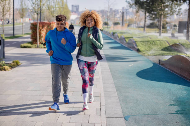istock Mother and son jogging in a public park 1398090196