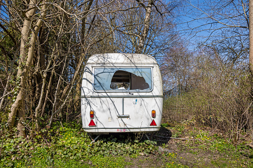 Abandoned caravan with a broken window found in Humlebæk which is a suburb to Copenhagen