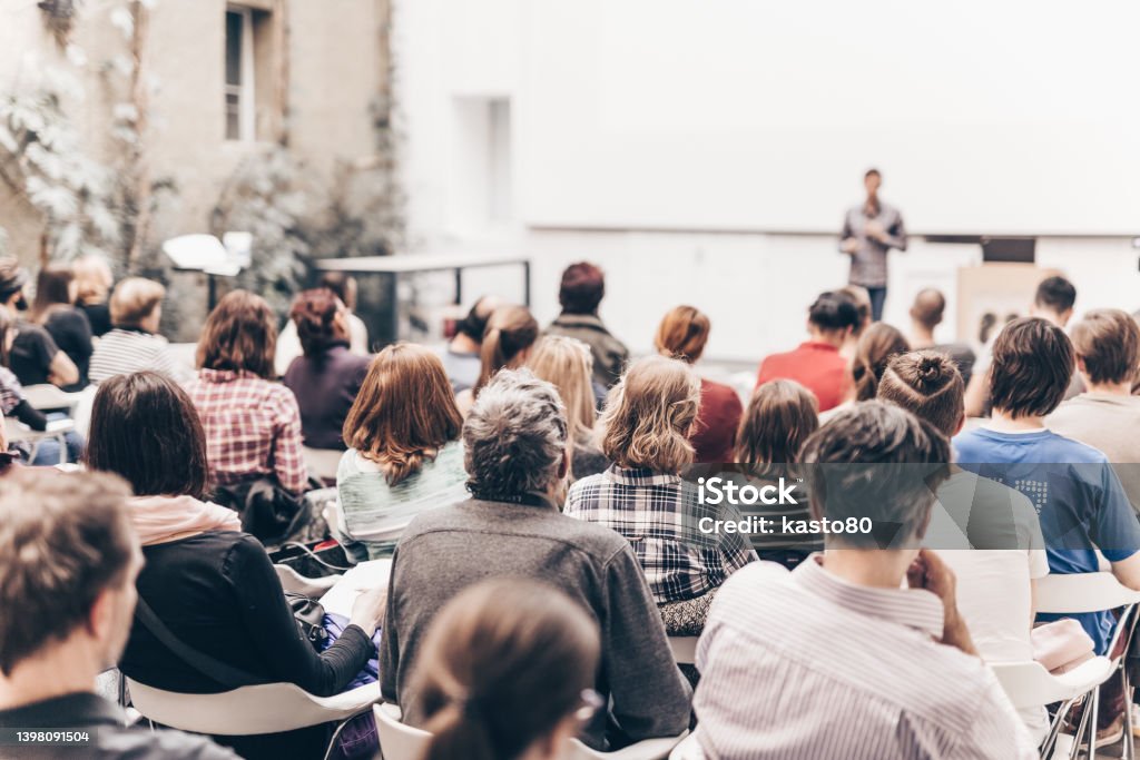 Rear View Of People Sitting In Auditorium  Conference - Event Stock Photo
