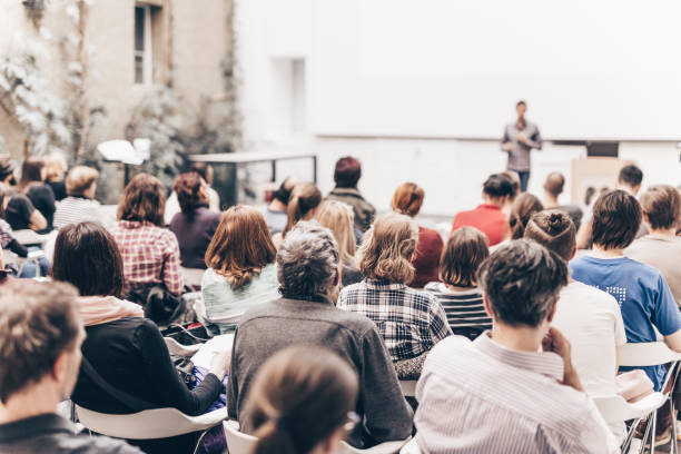 vista traseira de pessoas sentadas no auditório - conference - fotografias e filmes do acervo