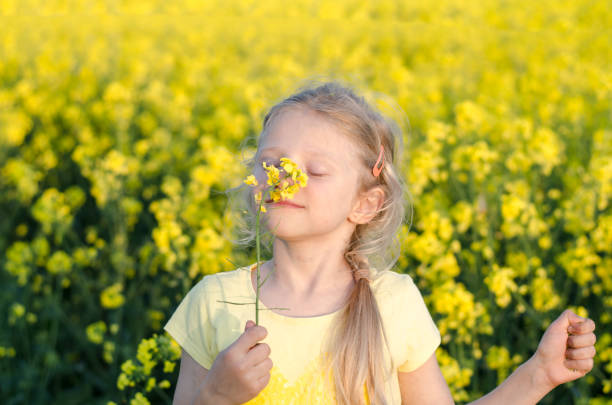 istock charming blond girl relaxing in yellow meadow 1398093021