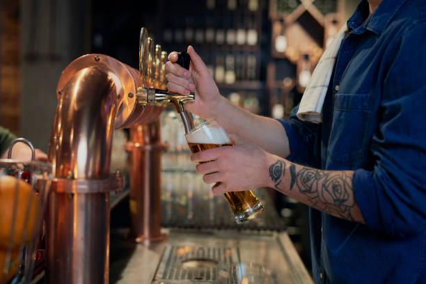 istock Midsection Of Bartender Filling Beer In Bottle 1398093181
