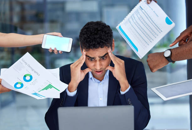 istock One anxious mixed race businessman feeling pressure and panic while working in a demanding busy office environment. Young overworked and exhausted entrepreneur trying to multitask deadlines. Mentally frustrated with burnout and stress 1398095901