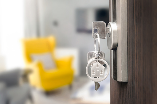 Buy new home concept. Key ring with keys in the lock in the door