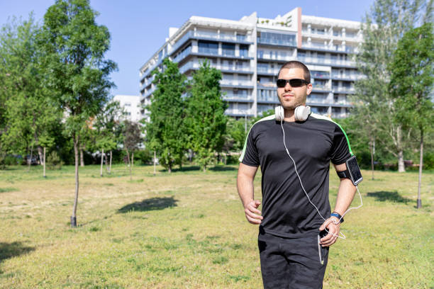 Man preparing for an outdoor run when wearing sunglasses and headphones on