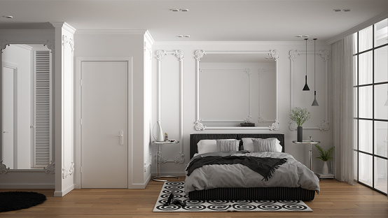 Modern white bedroom in classic room with wall moldings, parquet floor, double bed with duvet and pillows, minimalist bedside tables, mirror and decors. Interior design concept