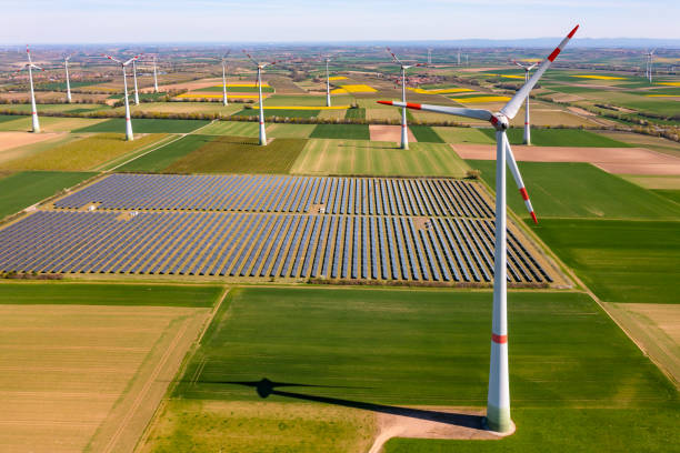 Solar modules of a solar park with wind turbines to produce green electricity for the Energiewende seen from above stock photo